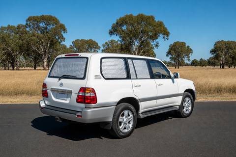 Solarscreen Touring Set on a white 100 Series Toyota Landcruiser GXL with tailgate: silver insulated screens on the tailgate window and rear side door windows
