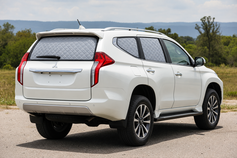 White Mitsubishi Pajero Sport with silver quilted insulated block-out rear Touring screens and clear front glass.