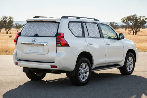 White Toyota Prado 150 Series with silver quilted insulated block-out Touring screens covering rear passenger, cargo and tailgate windows, with front glass clear.